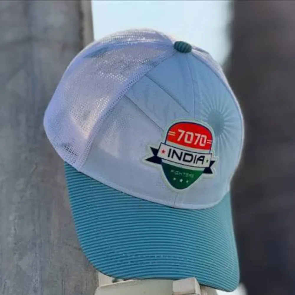 Angled view of the 11Sports light blue and white trucker cap featuring the India 7070 Fighters badge.