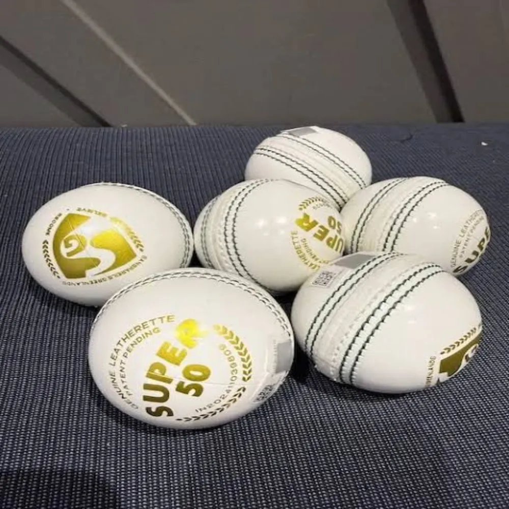 Six 11Sports red PVC training wind balls neatly arranged on synthetic grass, showcasing smooth molded seam ridges designed to simulate genuine seam movement without the risk of hard-ball injuries.