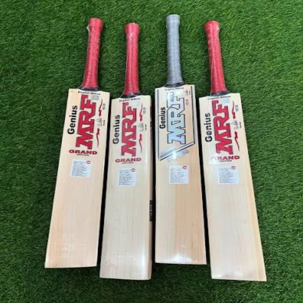 Four 11Sports MRF Genius Grand Edition cricket bats with red and silver grips aligned on synthetic turf.
