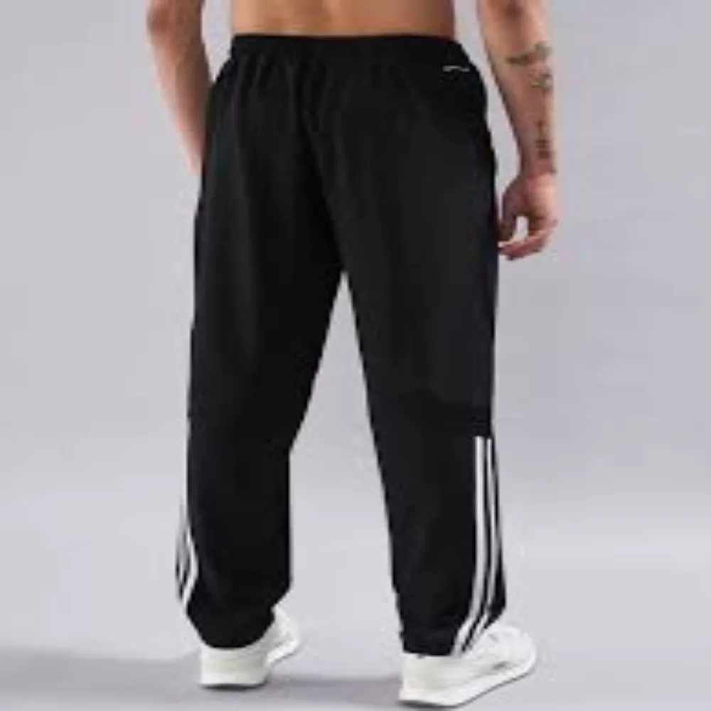 Back view of 11Sports matte black training track pants featuring white vertical side stripes near the calf.