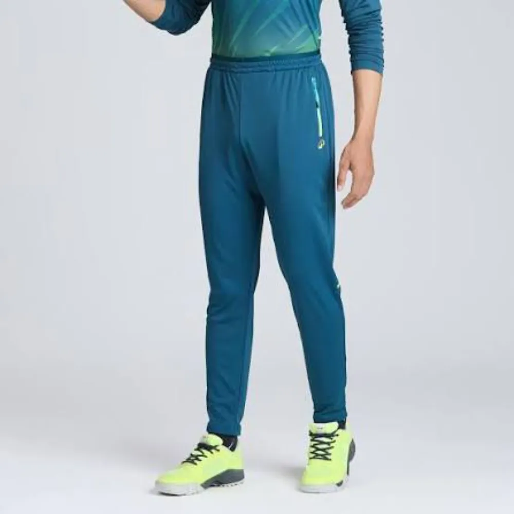 Full-length front view of 11Sports deep teal cricket track pants with neon green zipper accent pocket.