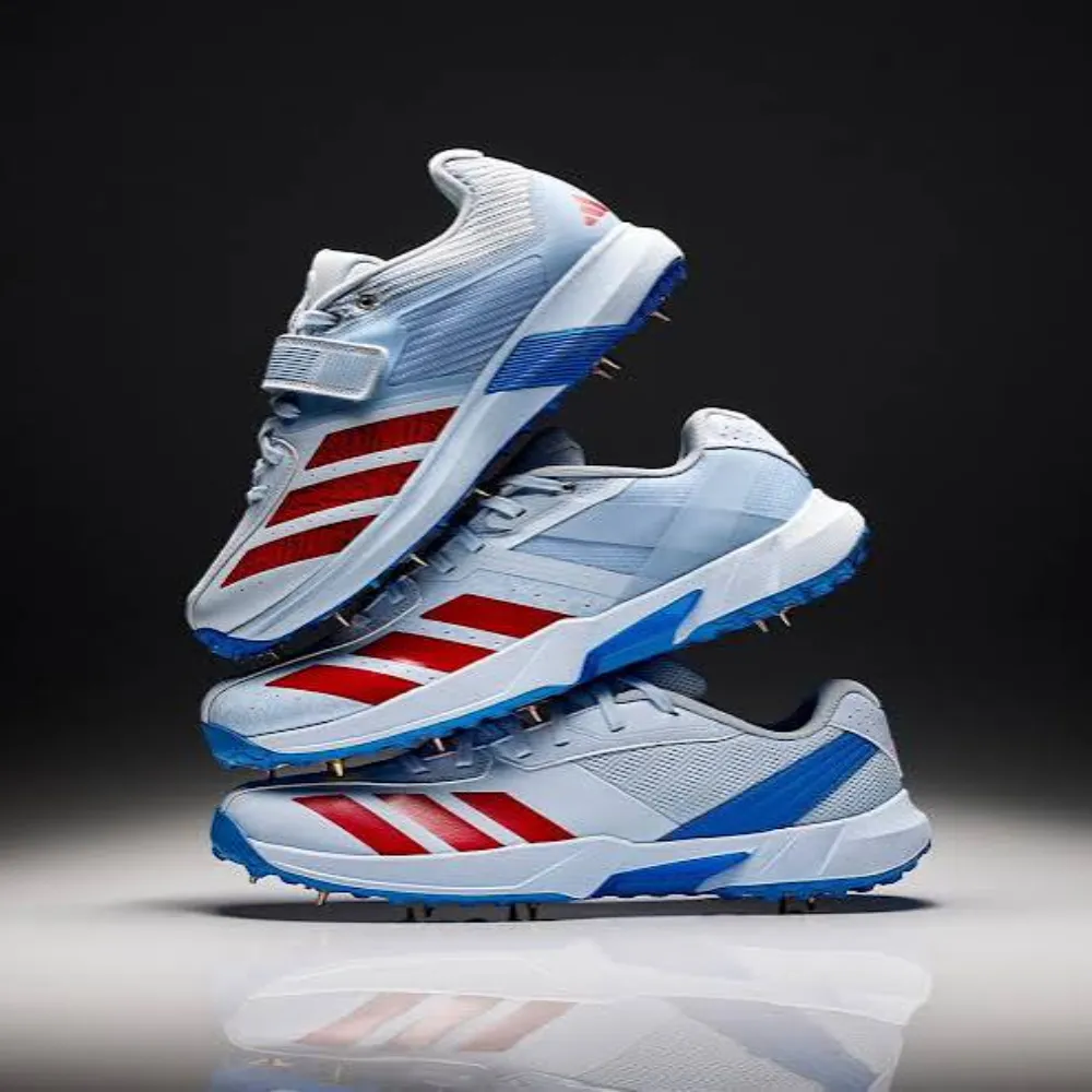 Stack of three 11Sports pro cricket spikes in sky blue, white, and red showing high-top midfoot strap.
